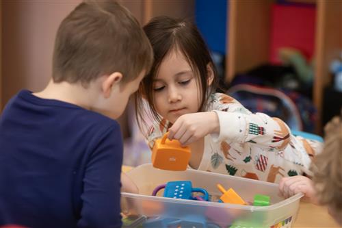 Two UPK students play with plastic locks